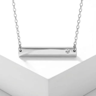Silver necklace with a bar pendant on a white background